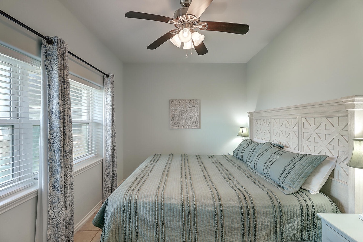 Your peaceful retreat features crisp linens and gentle natural light, with a ceiling fan keeping you cool and comfortable.