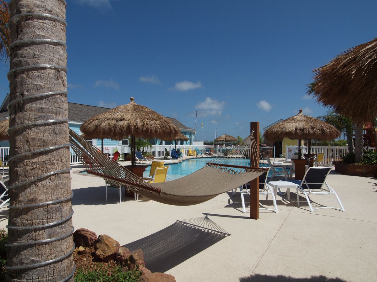 Relax in your tropical hammock beneath swaying palms, just steps from the sparkling pool.