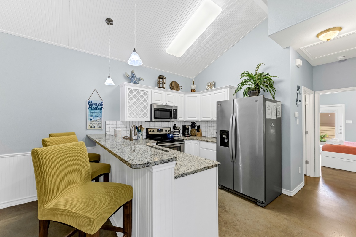 Gather around this bright kitchen island for morning coffee or evening conversations. Modern appliances and coastal charm create your perfect home base.