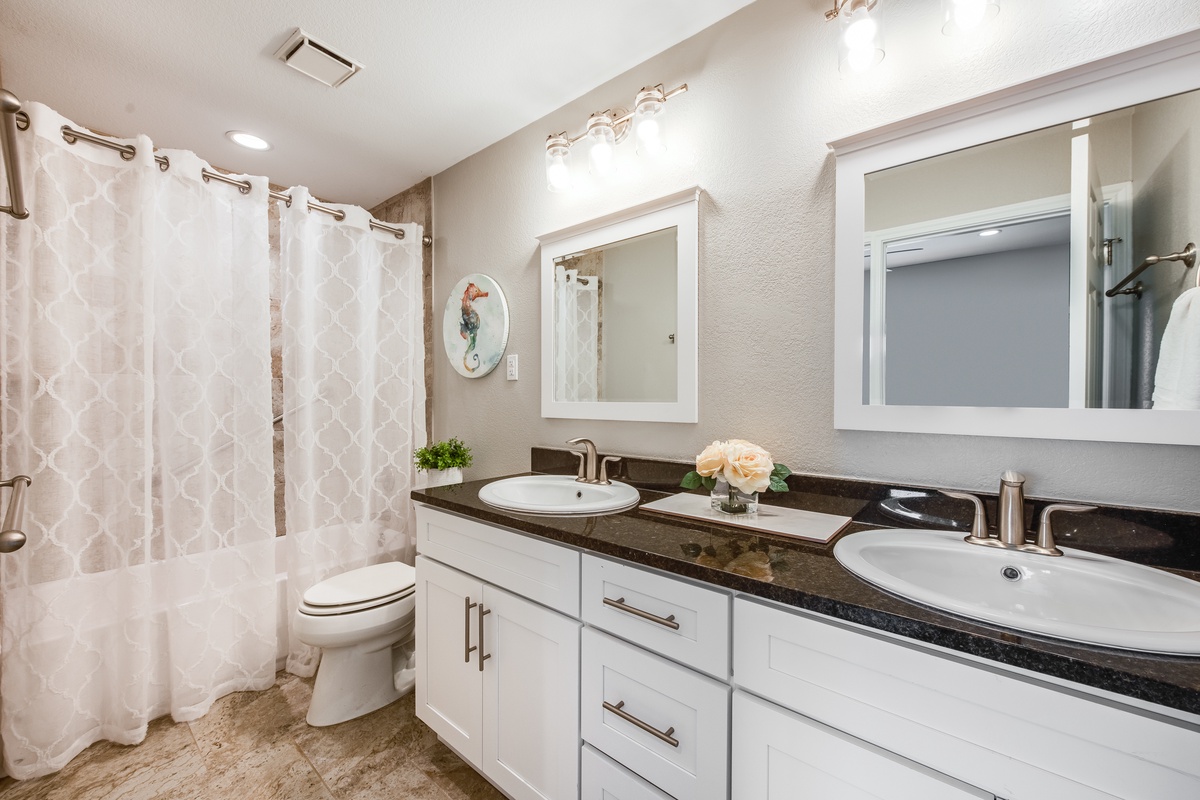 Unwind in this spa-like bathroom with dual vanities, elegant granite countertops, and a spacious shower to refresh after your adventures.