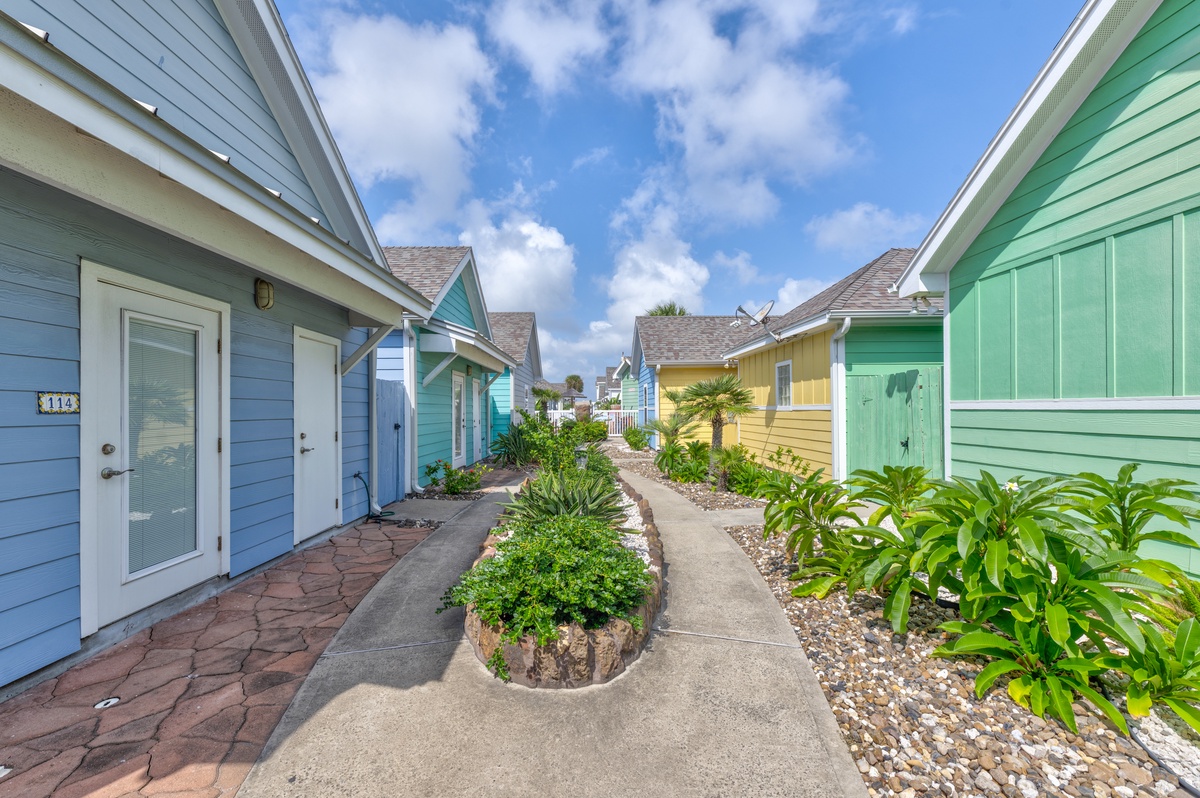 Colorful beach cottage community with tropical landscaping and charming coastal architecture.