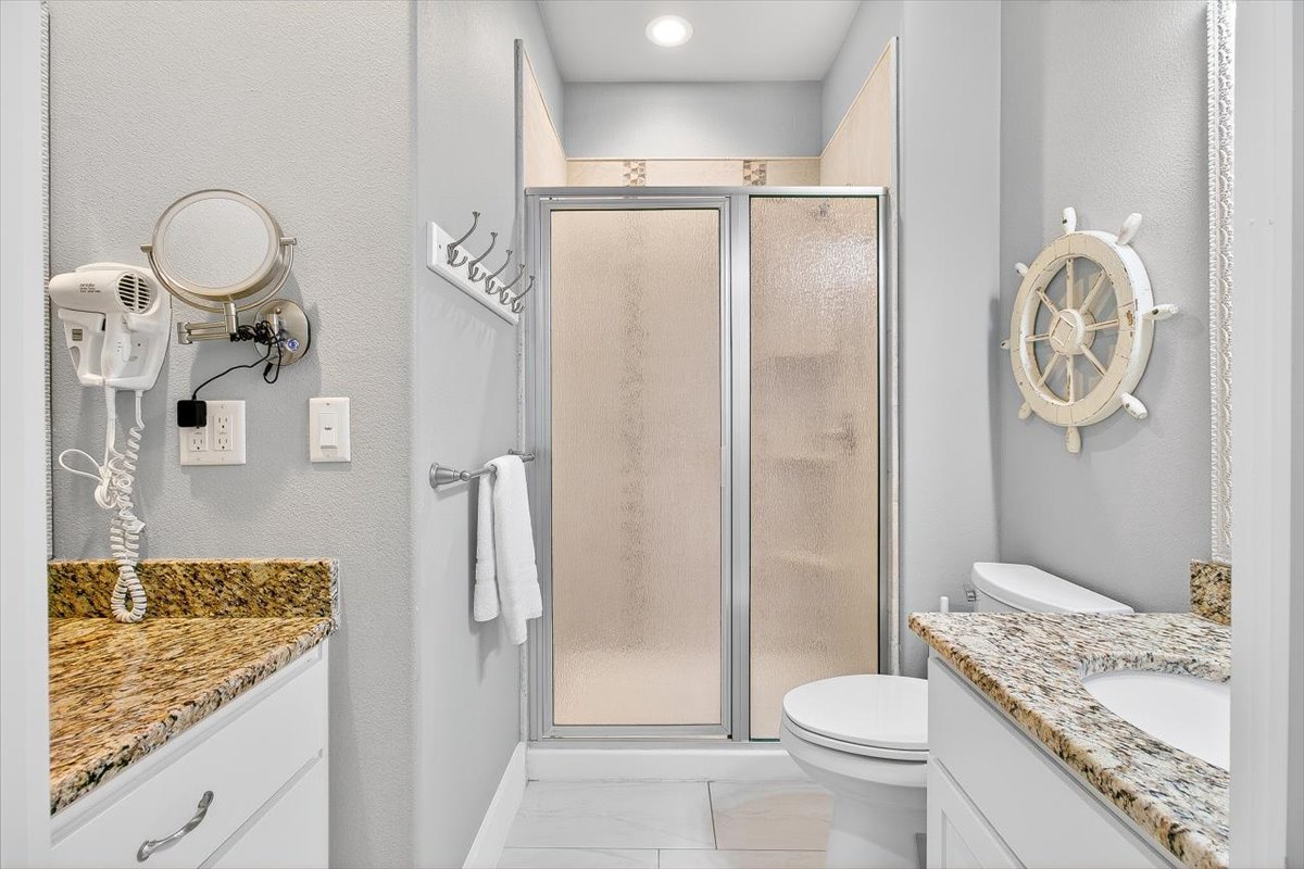Your private bathroom features granite countertops, spacious shower, and charming nautical touches that make getting ready feel like a seaside retreat.