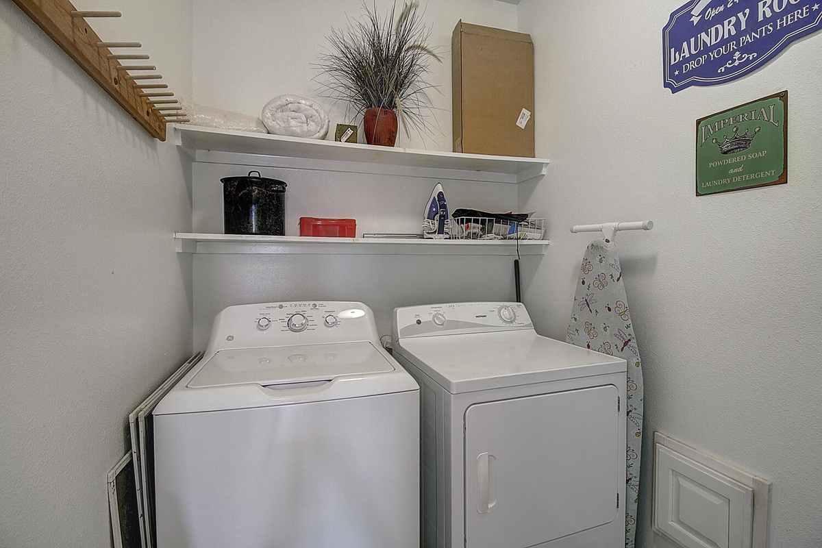Your private laundry room features a full-size washer and dryer with shelving for supplies and charming vintage-inspired decor.