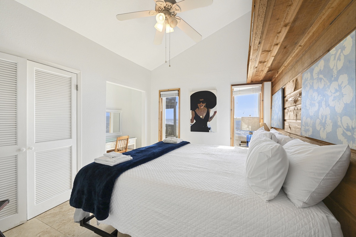 Settle into your bright, airy retreat featuring vaulted ceilings, rustic wood-beam accents, and plush bedding that invites restful nights and lazy mornings under the gentle breeze of the ceiling fan.