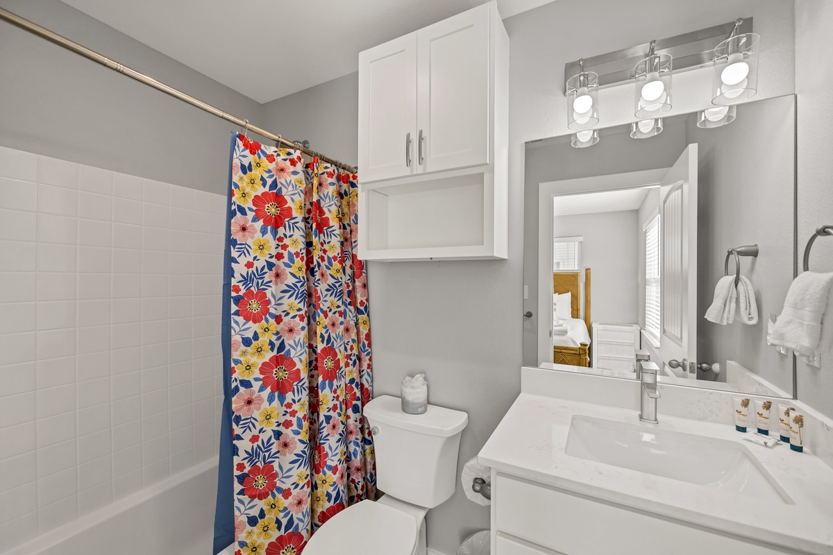 Step into your bright, cheerful bathroom featuring a floral shower curtain, modern vanity, and thoughtful storage for all your essentials.