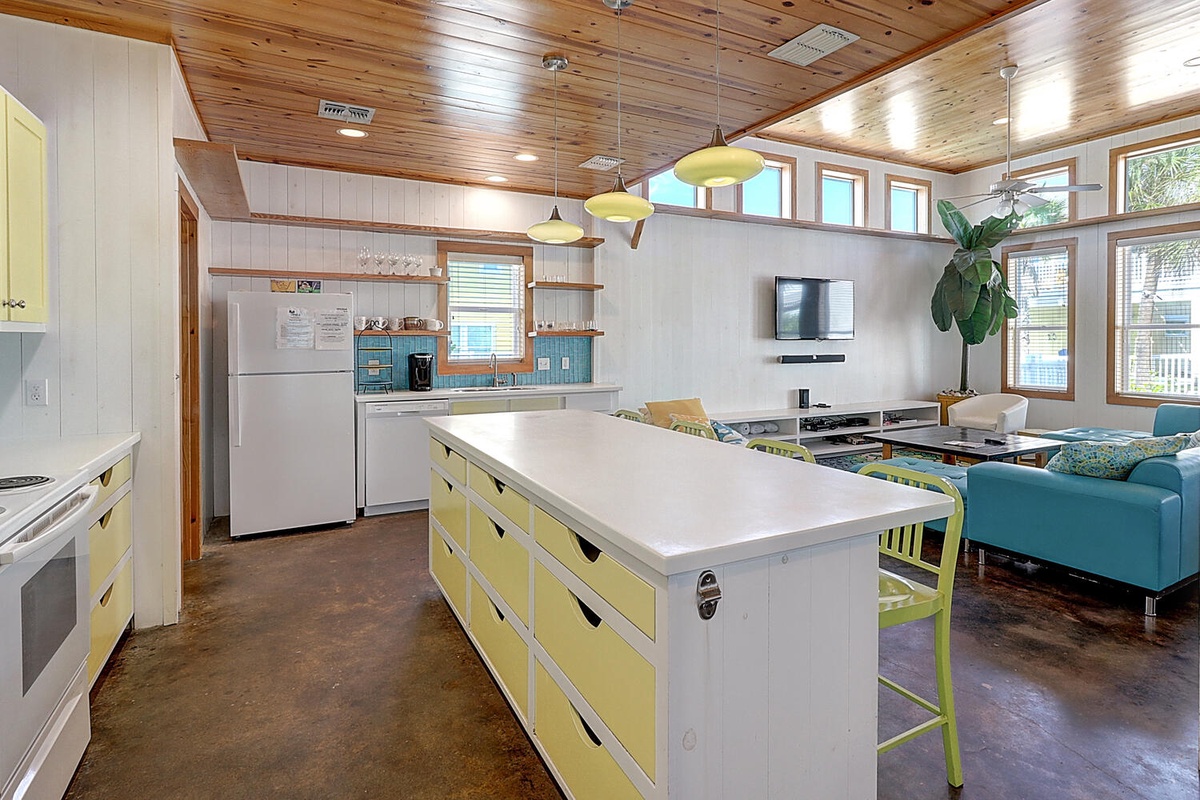 Your bright modern kitchen flows seamlessly into the living area, featuring cheerful yellow cabinets and sleek appliances for memorable meals together.