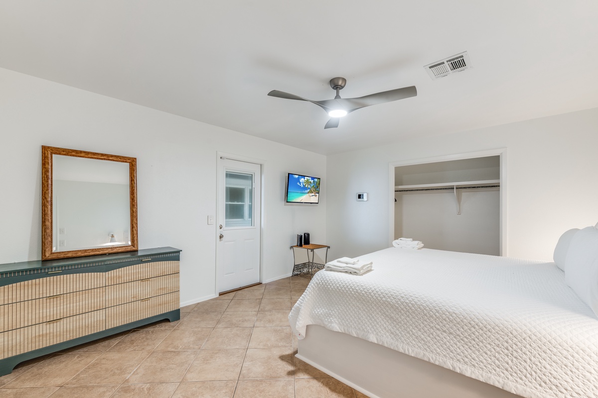 Drift off to peaceful sleep in your bright, airy bedroom with crisp white linens, ceiling fan comfort, and convenient TV entertainment.