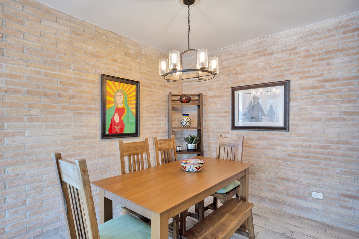 Gather around your warm dining space, where exposed brick walls and thoughtful artwork create the perfect setting for memorable meals together.