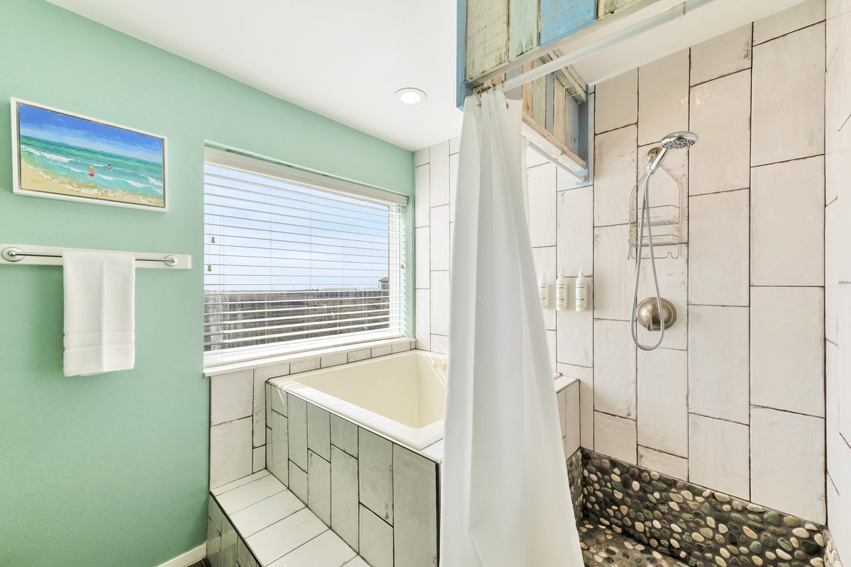Unwind in your spa-like bathroom featuring a luxurious soaking tub and spacious shower with natural light streaming through.