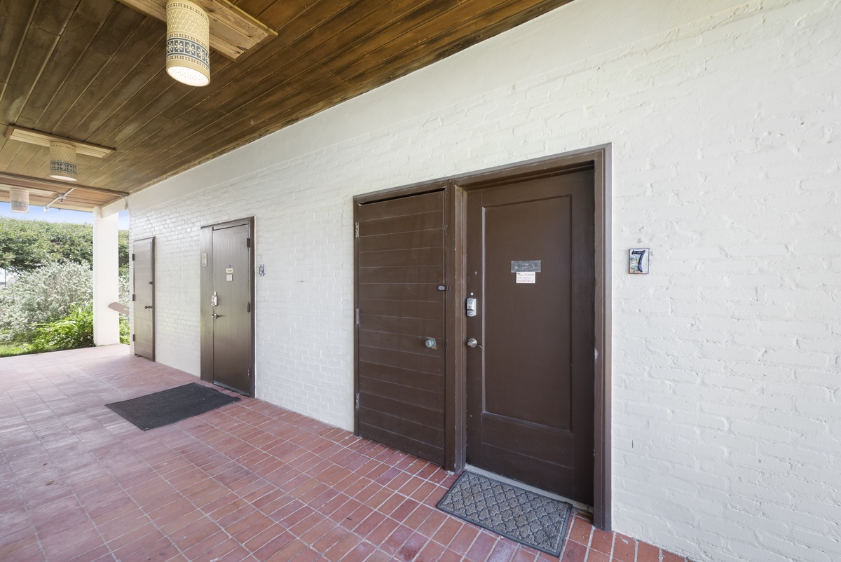 Property entrance with unit number 7 marker and brick pathway.
