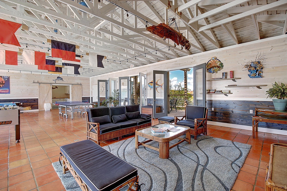 Relax in this stunning open-concept living space with soaring vaulted ceilings, comfortable seating, and panoramic windows framing beautiful outdoor views.