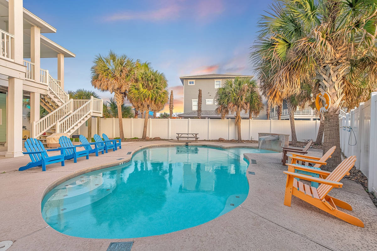 Dive into your private oasis! Crystal-clear waters beckon while colorful Adirondack chairs invite poolside relaxation under swaying palms.