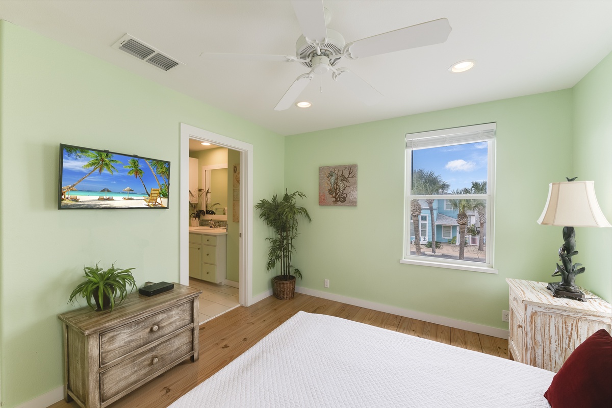 Relax in your peaceful bedroom with coastal views and tropical decor creating the perfect beach getaway atmosphere.