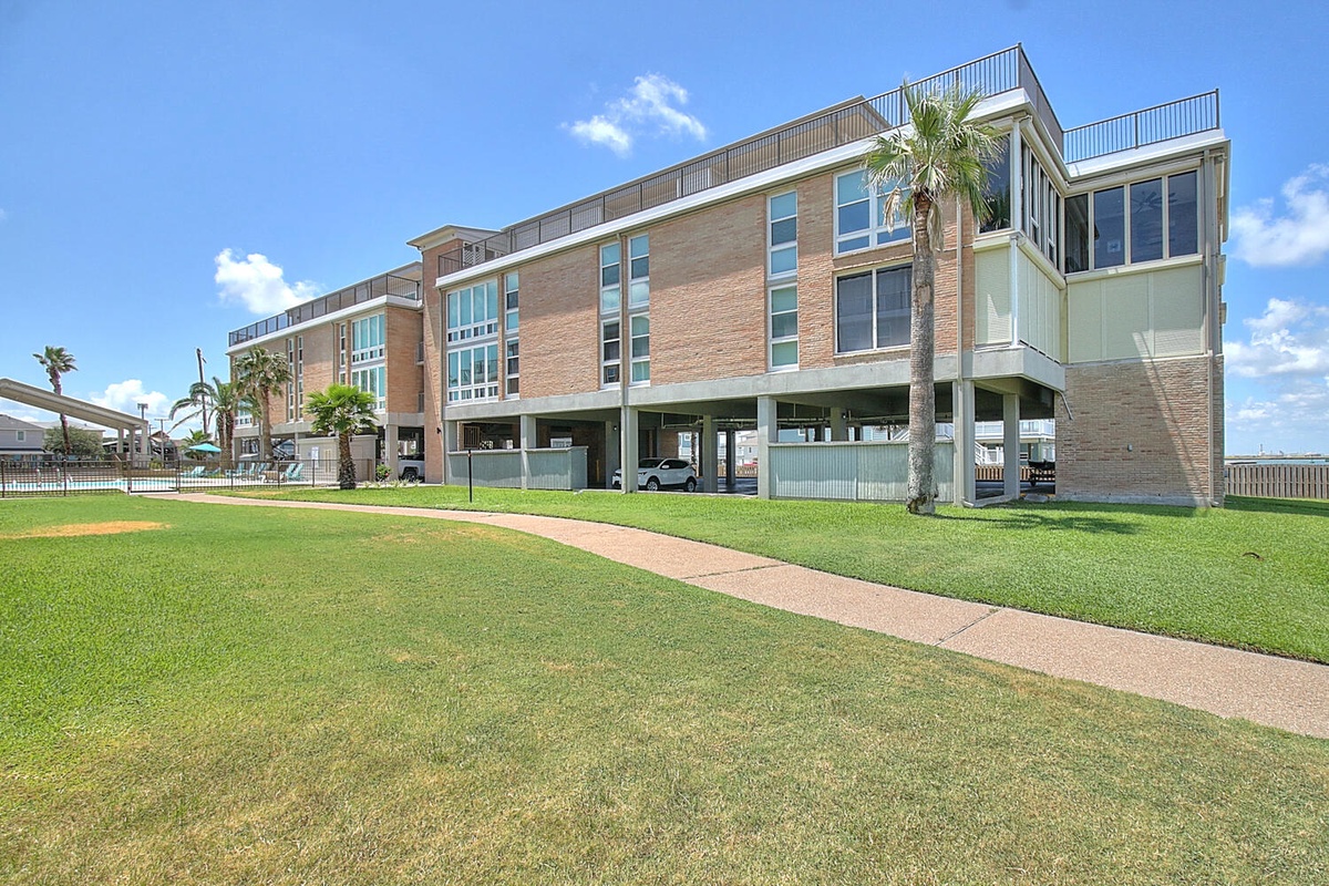 Modern brick property with tropical landscaping and convenient ground-level parking in a peaceful residential setting.