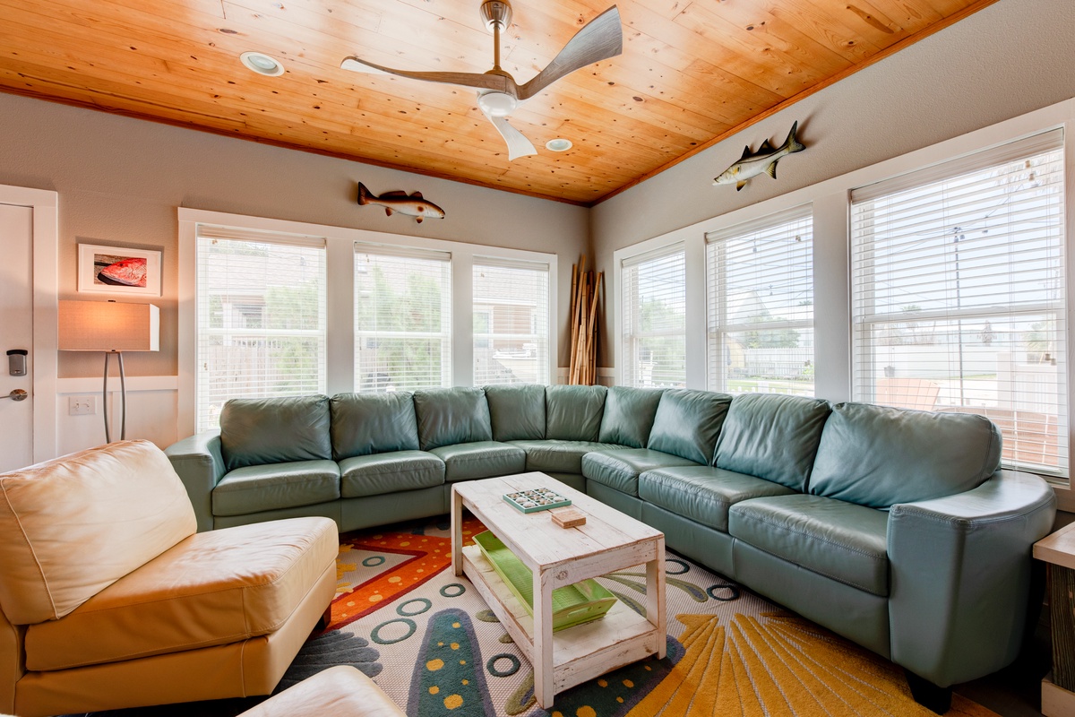 Relax in this spacious living room with wraparound seating, warm wood ceiling, and nautical touches that make you feel right at home.
