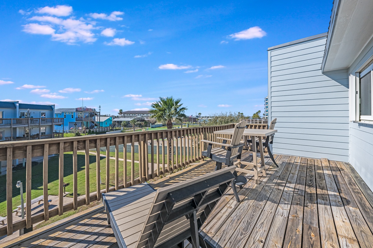 Relax on your private deck with outdoor dining and peaceful neighborhood views under endless blue skies.