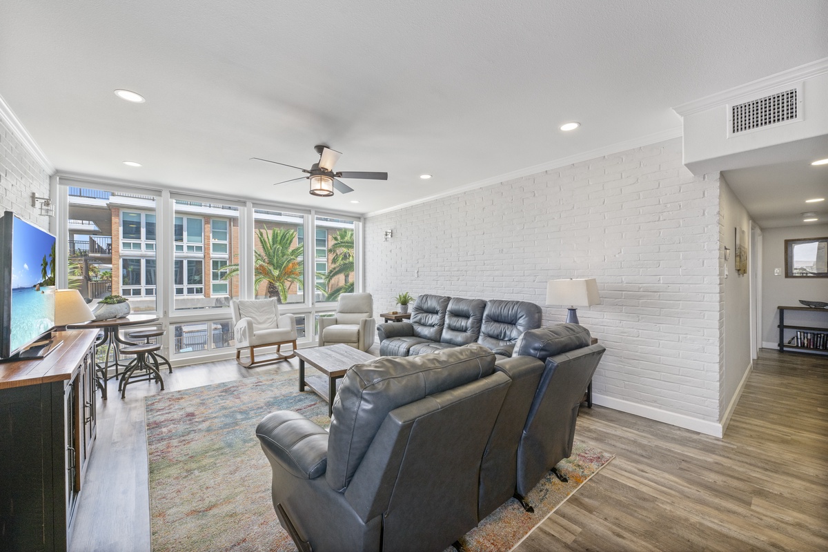 Unwind in your spacious living room with leather seating, exposed brick walls, and city views through oversized windows.