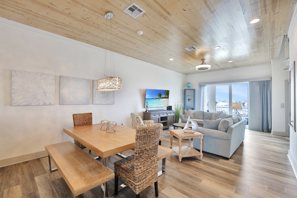 Relax in your stylish living space with stunning wood ceiling, modern furnishings, and bright city views through floor-to-ceiling windows.