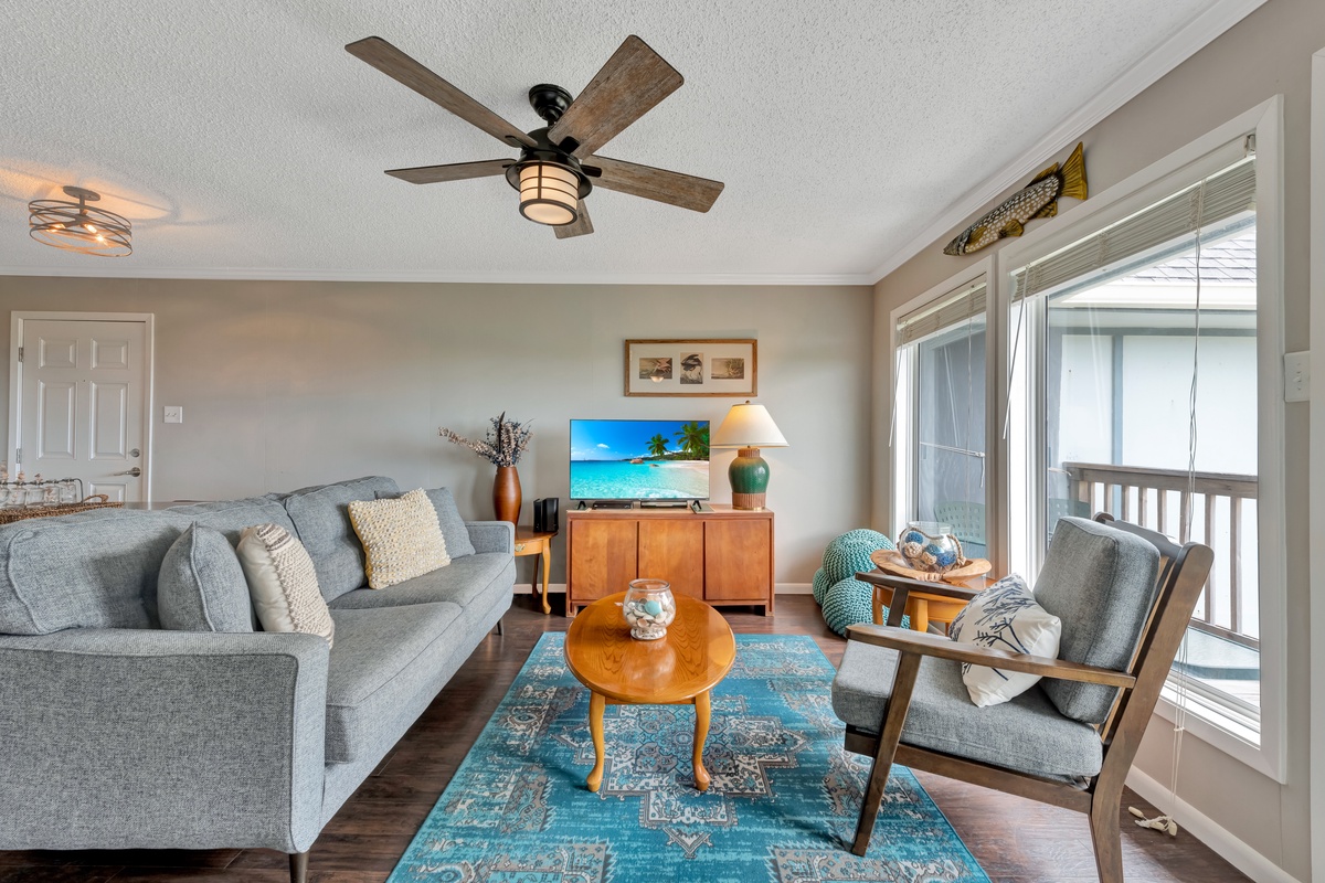 Your bright living space features comfortable seating and coastal decor, with access to your private balcony for relaxing moments.