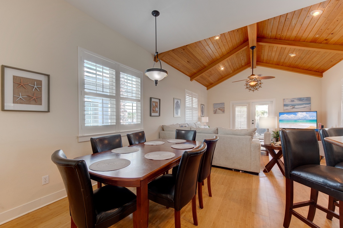 Gather around your spacious dining table beneath soaring wood-beam ceilings, sharing memorable meals while natural light streams through plantation shutters.