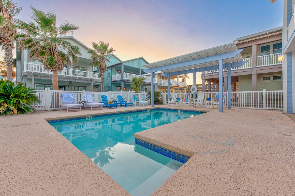 Dive into your private pool oasis surrounded by tropical palms and colorful beach chairs, perfect for morning swims and sunset relaxation.