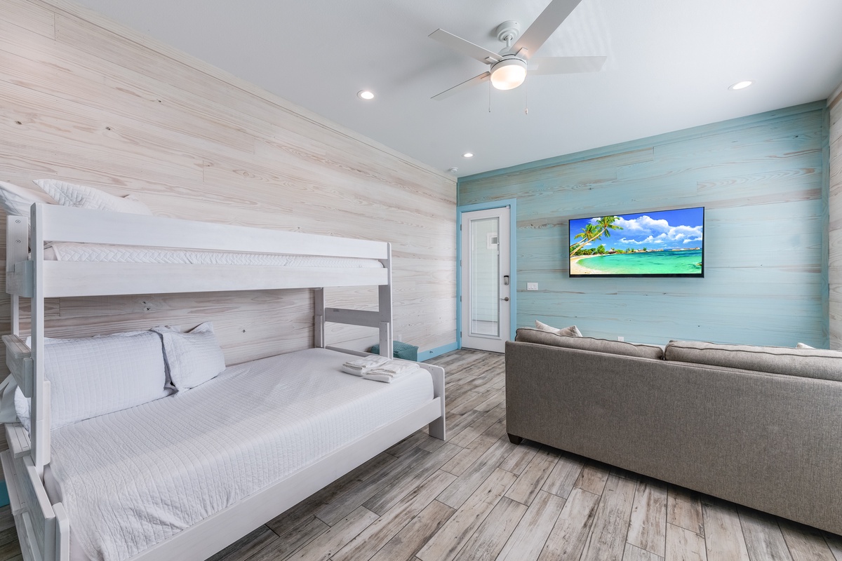 Your beach-themed room combines comfort and function with a cozy bunk bed, sofa seating, and entertainment system for family relaxation.