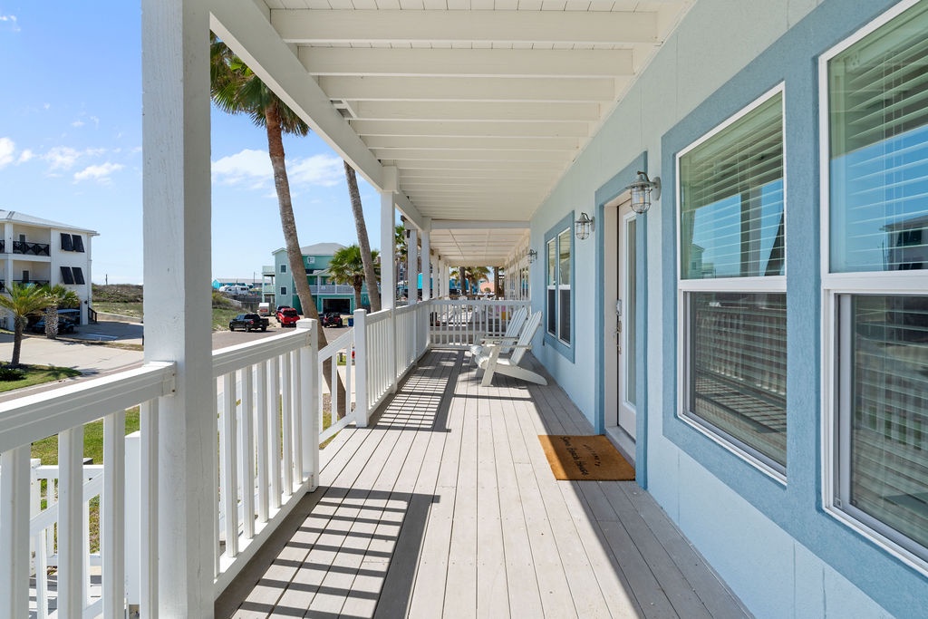 Step onto your private covered porch where coastal breezes flow through white railings and rocking chairs await lazy afternoons in paradise.