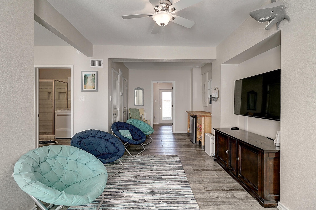 Unwind in your stylish living space with cozy papasan chairs and modern entertainment center for relaxing evenings.