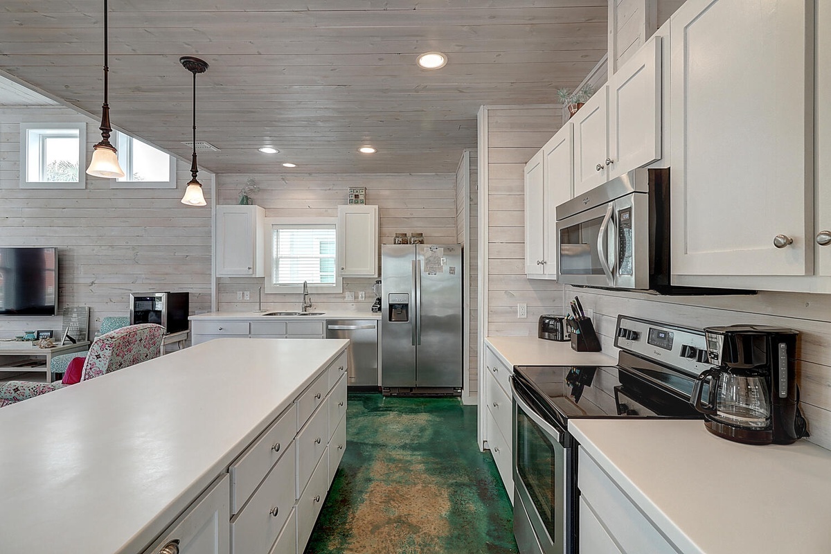 Your spacious kitchen awaits with modern appliances, ample counter space, and charming coastal touches for your culinary adventures.