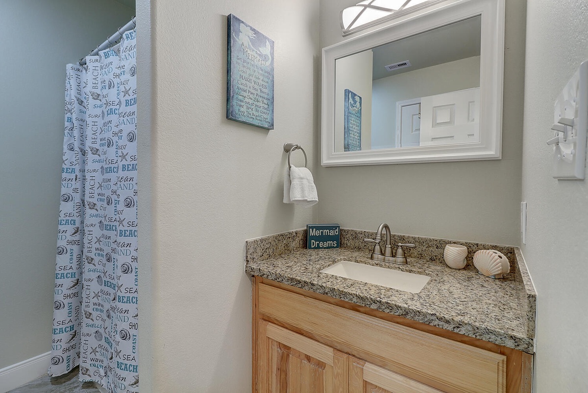 Freshen up in your coastal-themed bathroom with granite counters and charming seashell accents that bring ocean vibes indoors.
