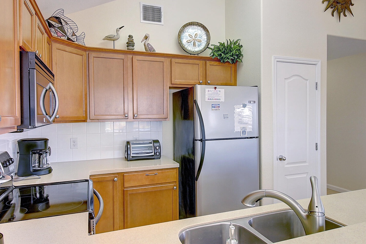Prepare your favorite meals in this fully equipped kitchen with modern appliances and warm wood cabinetry.