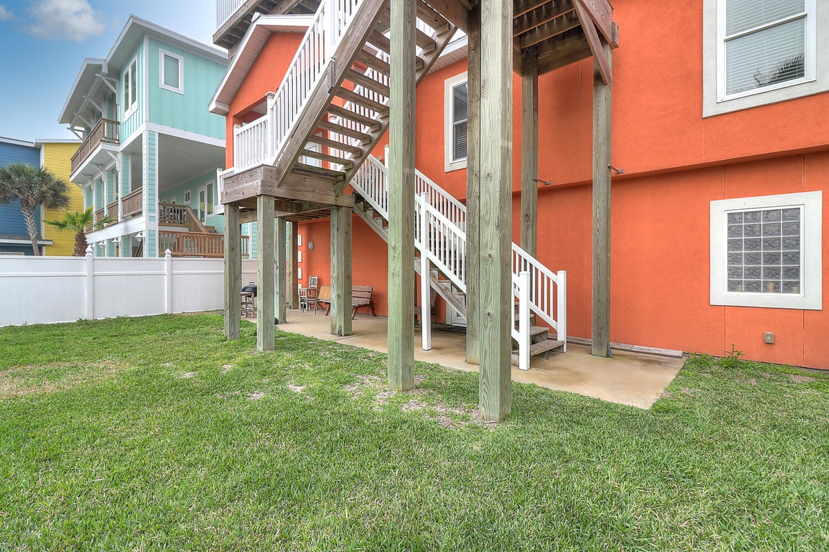 Colorful beachside buildings create a vibrant neighborhood setting with elevated walkways and tropical landscaping.