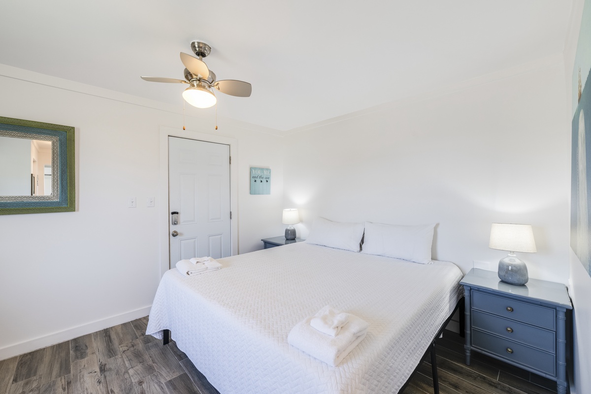 Drift off in a plush king bed dressed in crisp white linens, creating the perfect retreat after a day of sun and sand.