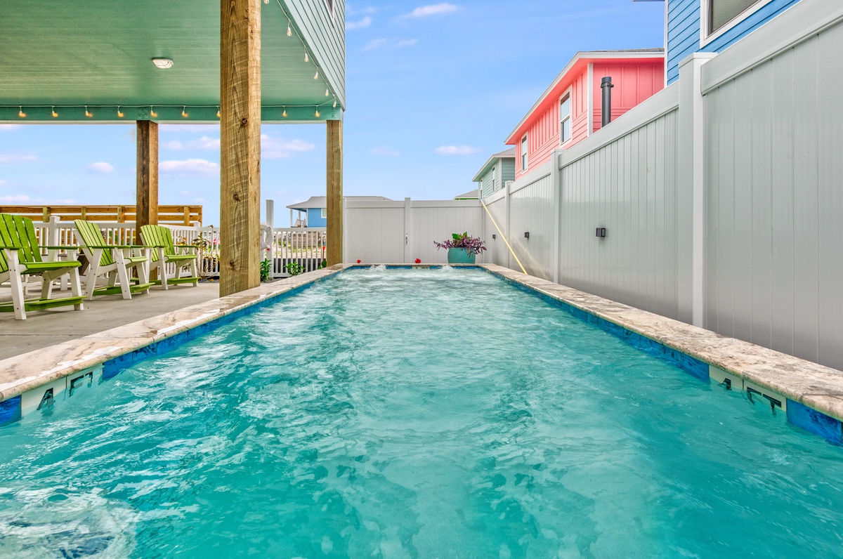 Dive into your own private oasis with this stunning pool surrounded by colorful beach houses and comfortable seating.