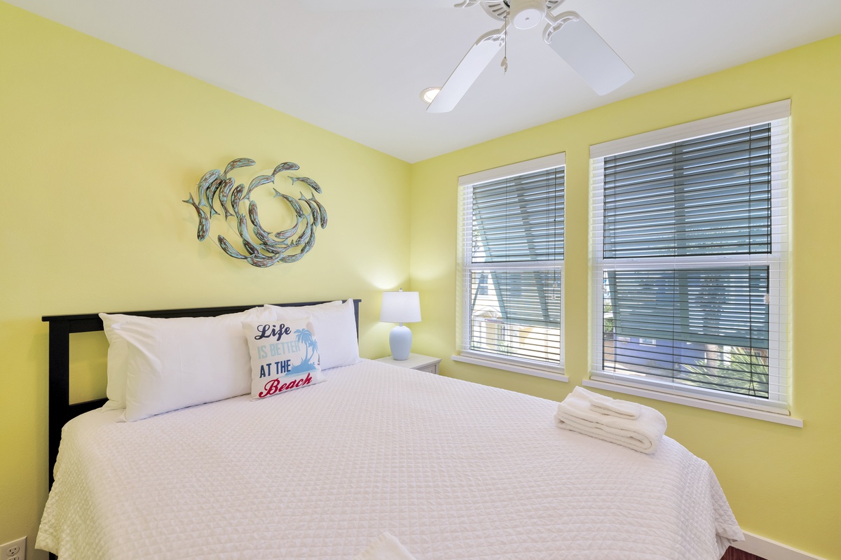 Drift off peacefully in your sunny beach-themed bedroom, complete with crisp linens, coastal art, and a ceiling fan for comfort.