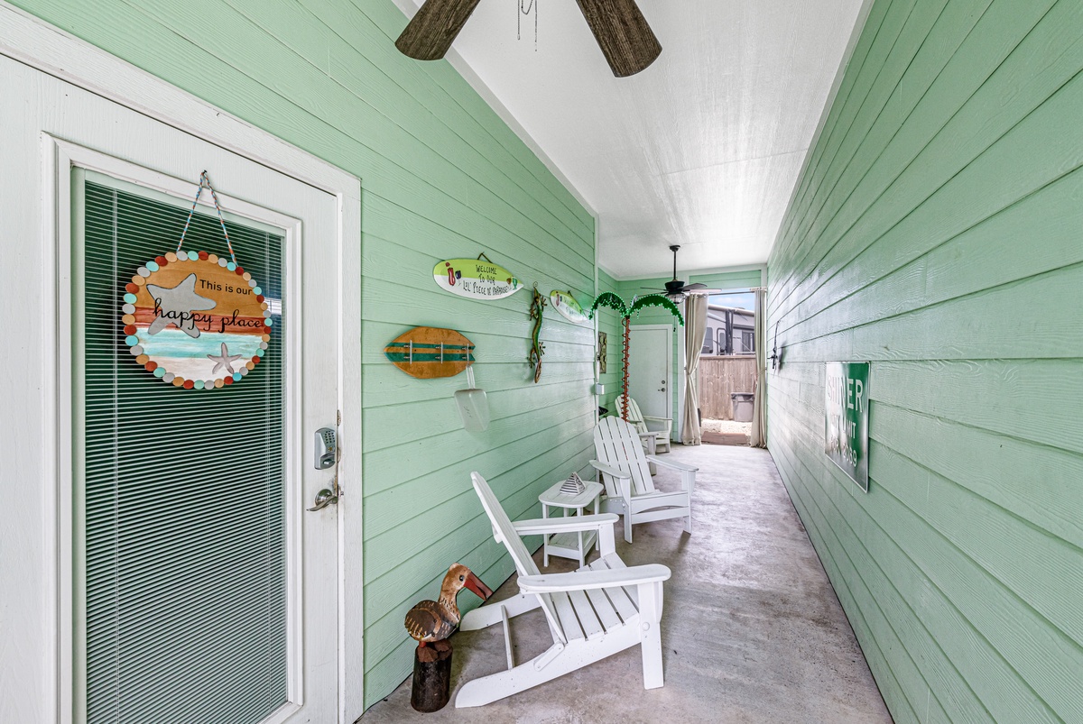 Settle into your private covered porch with Adirondack chairs, perfect for morning coffee or evening relaxation in this charming coastal retreat.