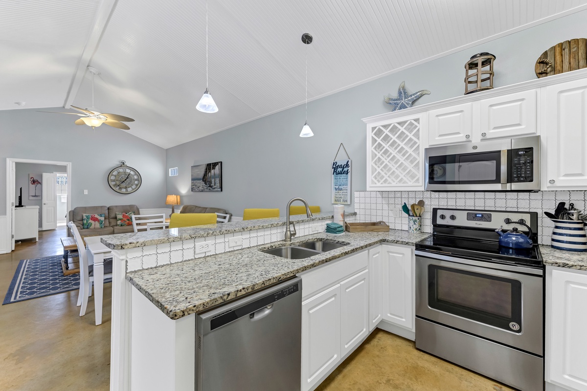 Your spacious open-concept kitchen features granite countertops, stainless steel appliances, and coastal charm - perfect for cooking memorable vacation meals.