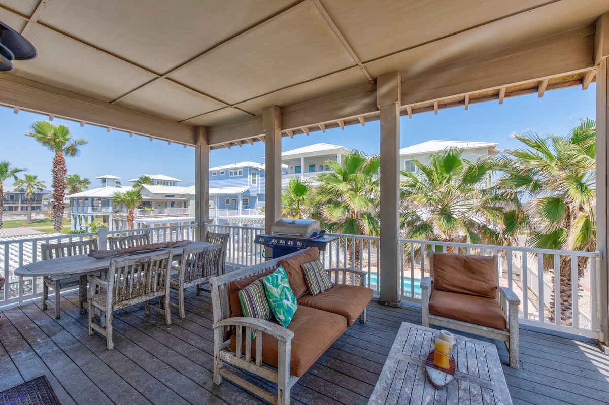 Relax on your private covered deck with comfortable seating, dining table, and BBQ while enjoying tropical palm views.