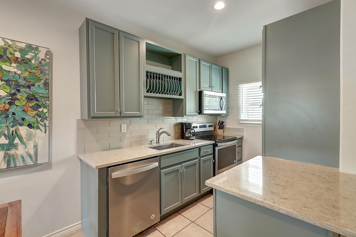Your fully equipped kitchen features elegant sage cabinets, granite counters, and stainless appliances for effortless meal preparation.