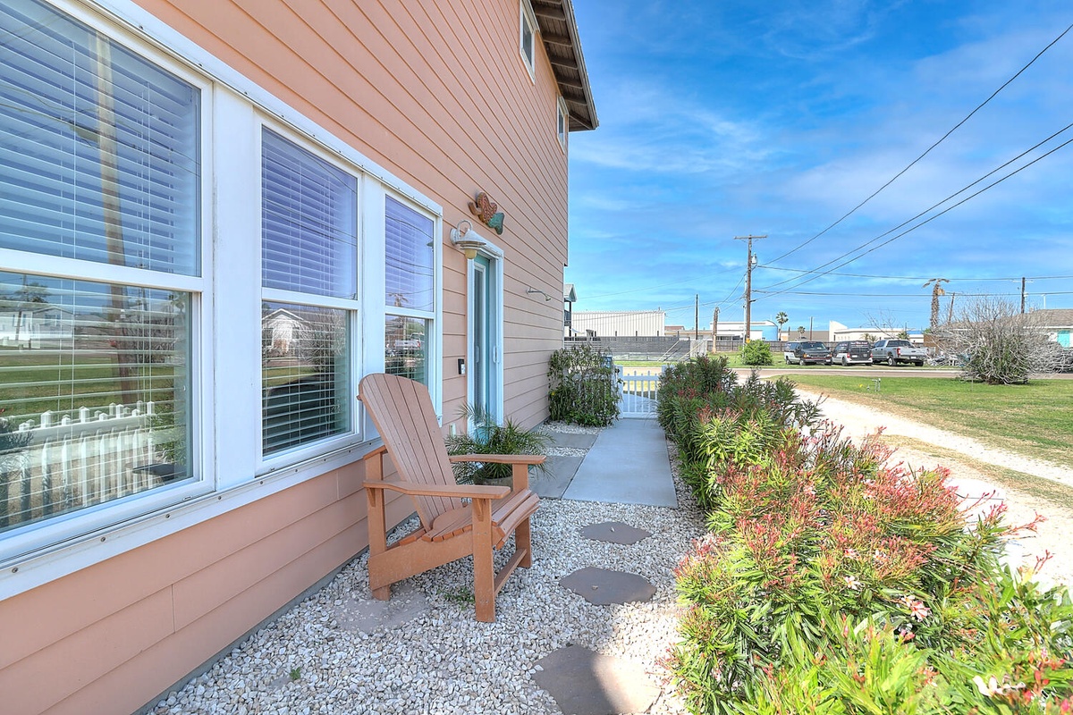 Step onto your private patio and settle into the cozy Adirondack chair, surrounded by colorful landscaping and peaceful gravel pathways.