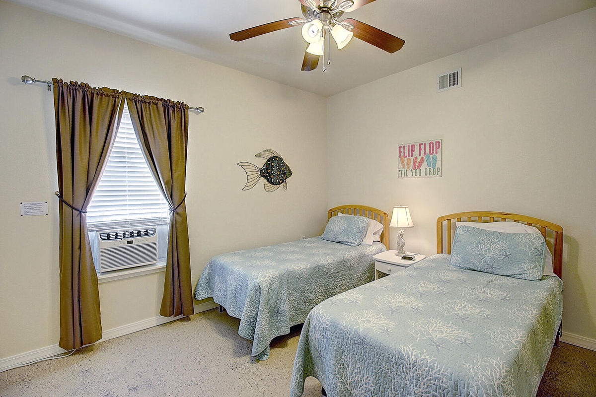 Unwind in your peaceful twin bedroom with coastal touches, where soft blue linens and gentle breezes create the perfect retreat for restful nights.