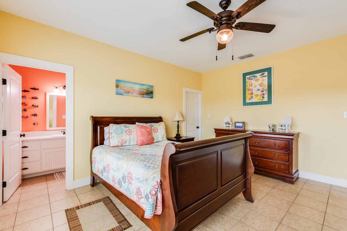 Rest in your coastal-themed bedroom with warm yellow walls, sleigh bed, and gentle ceiling fan keeping you cool and comfortable.