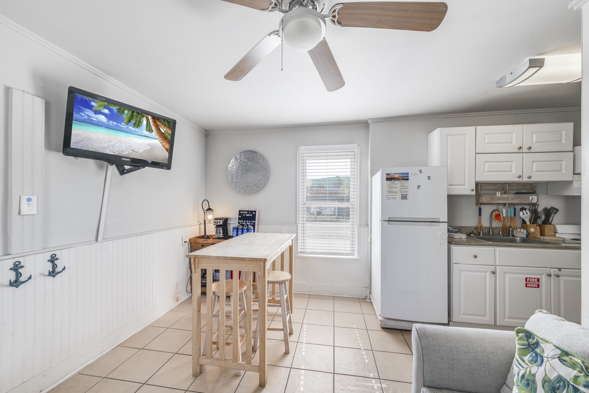 Your bright kitchen invites you to prepare morning coffee while watching the sunrise on TV, complete with coastal charm.