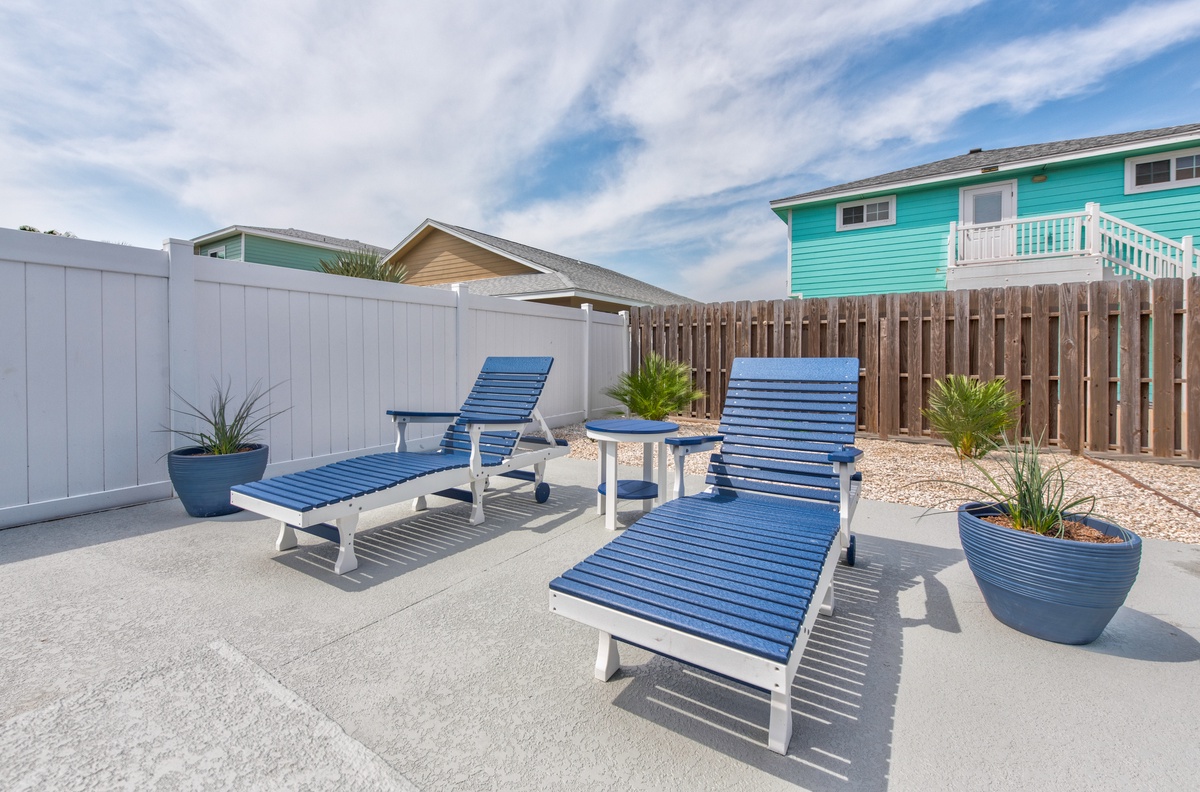Soak up the sun on your private patio with comfortable loungers and coastal-inspired planters creating your perfect outdoor retreat.
