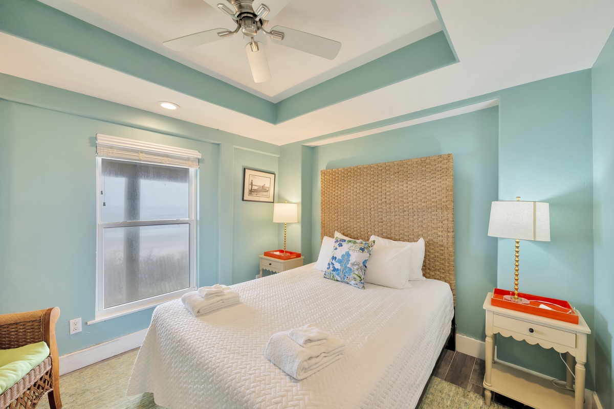 Drift into peaceful sleep in your coastal-inspired bedroom with soft aqua walls and woven headboard creating a tranquil retreat.