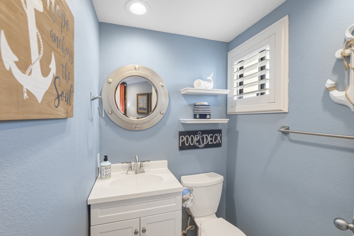 Step into your charming nautical-themed powder room with playful coastal décor and fresh blue walls that create a welcoming seaside retreat.