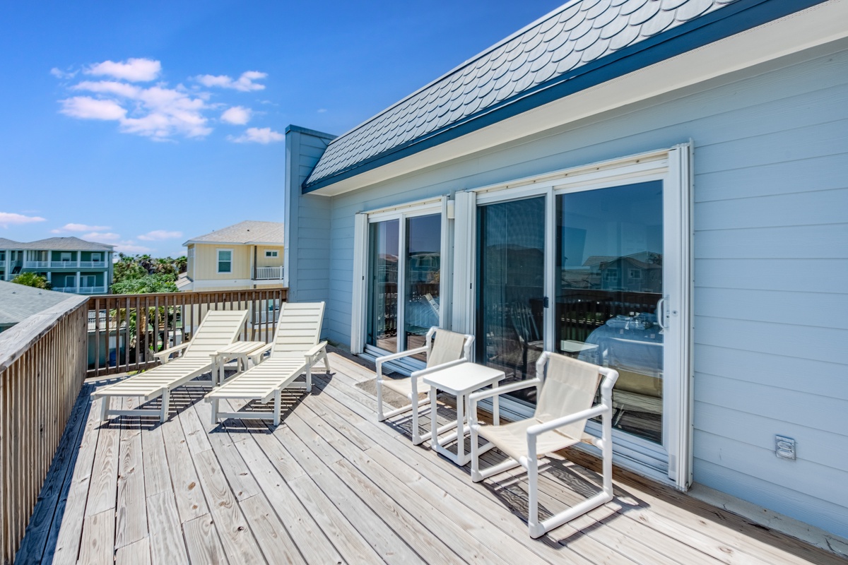 Relax on your private deck with comfortable lounge chairs, soaking up coastal sunshine while enjoying peaceful neighborhood views.