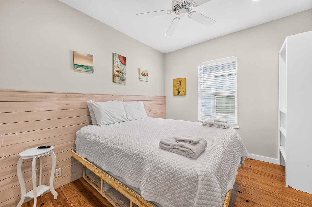 Slip into crisp linens and unwind in your serene bedroom, where soft coastal touches and warm wood accents create a peaceful retreat after a day of adventure.