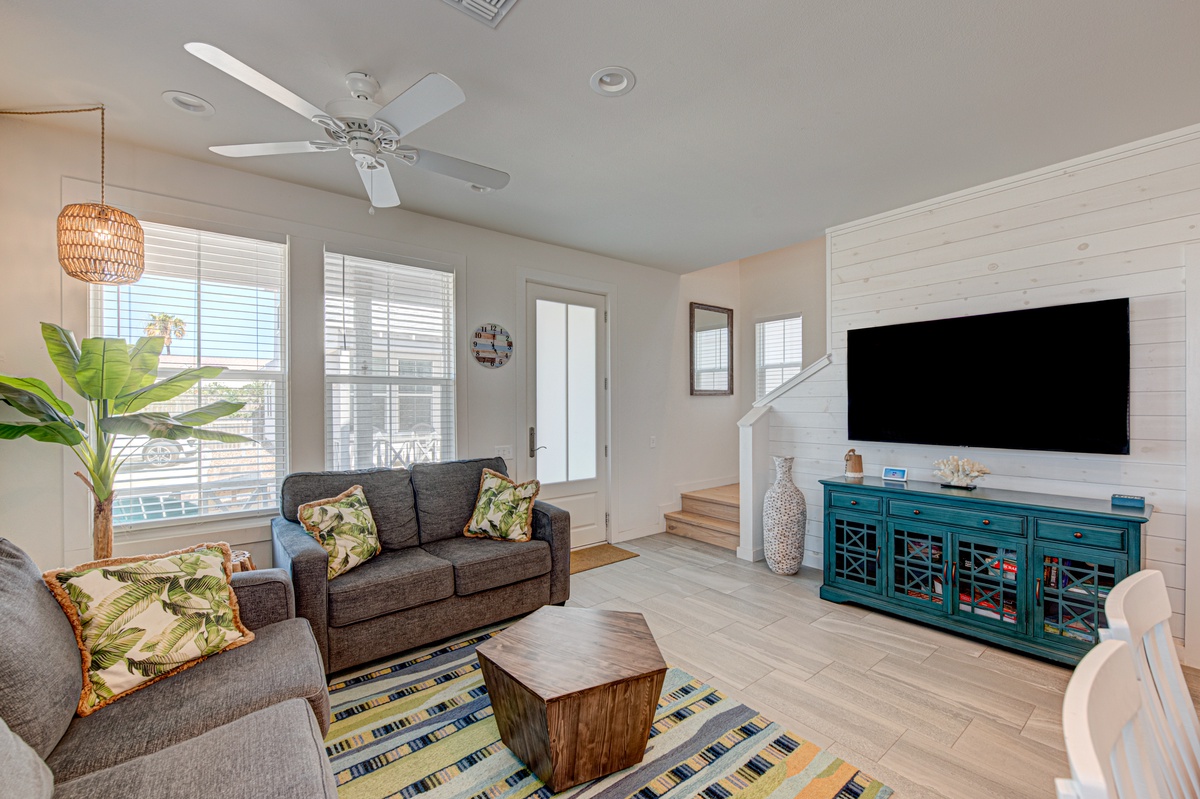Relax in your bright, airy living space with tropical touches and modern comfort. The shiplap accent wall frames your entertainment area perfectly.