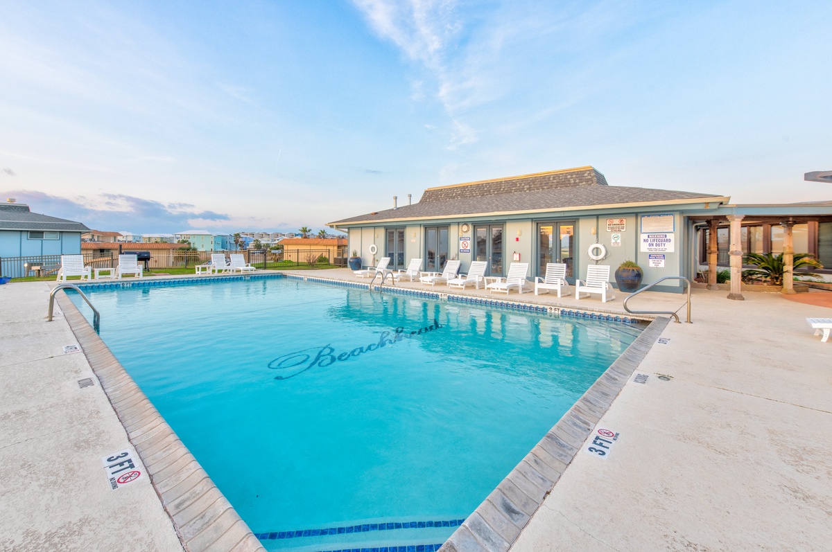 Sparkling blue waters await at this beautiful community pool, complete with comfortable loungers for your perfect beach getaway relaxation.